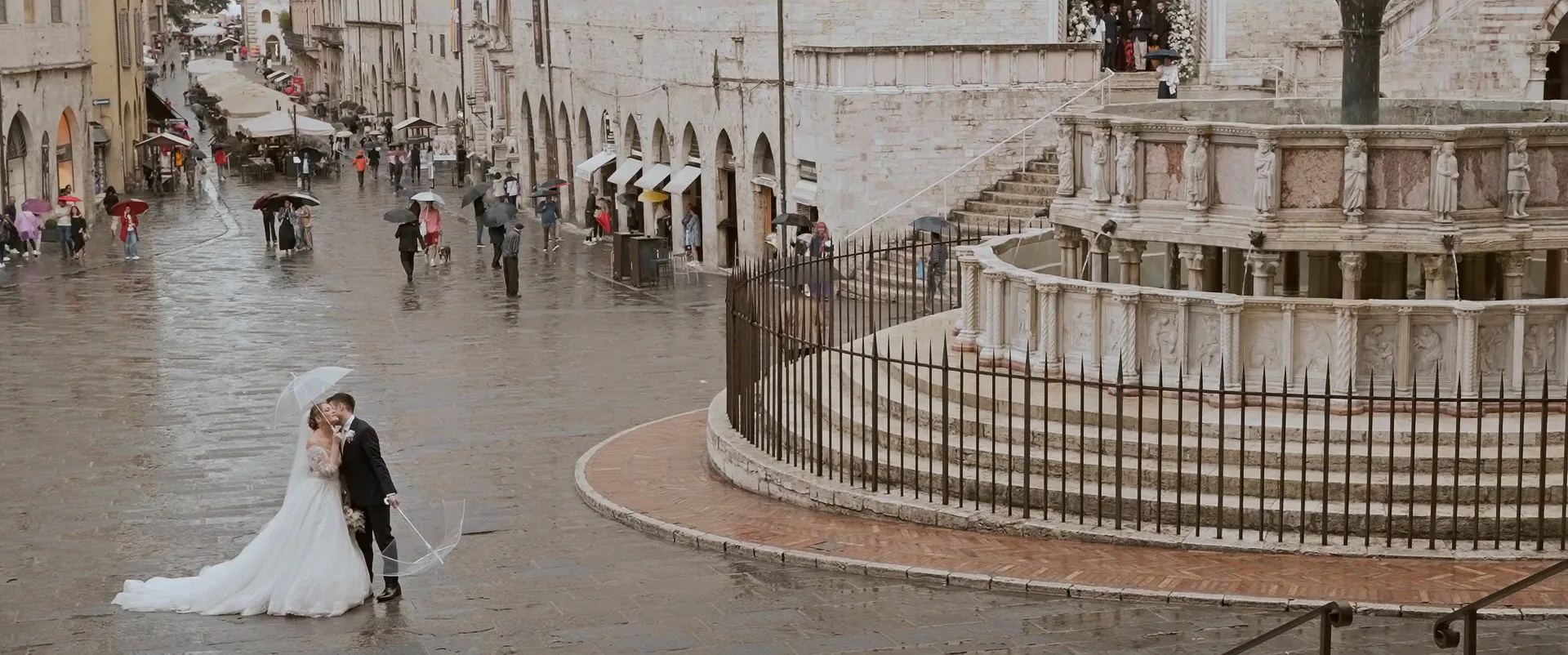 Arturo e Susanna sotto l’ombrello accanto alla Fontana Maggiore, in piazza IV Novembre a Perugia, fotogramma dal loro film