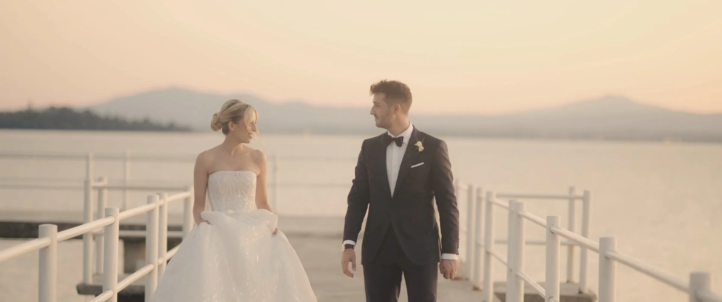 Emanuele ed Elena sul pontile del Lago Trasimeno al tramonto, fotogramma dal loro film