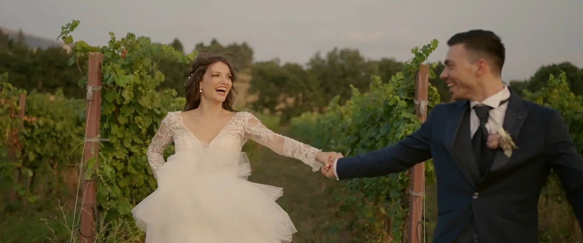 Giada e Marco si tengono per mano tra le vigne al tramonto, fotogramma dal loro film
