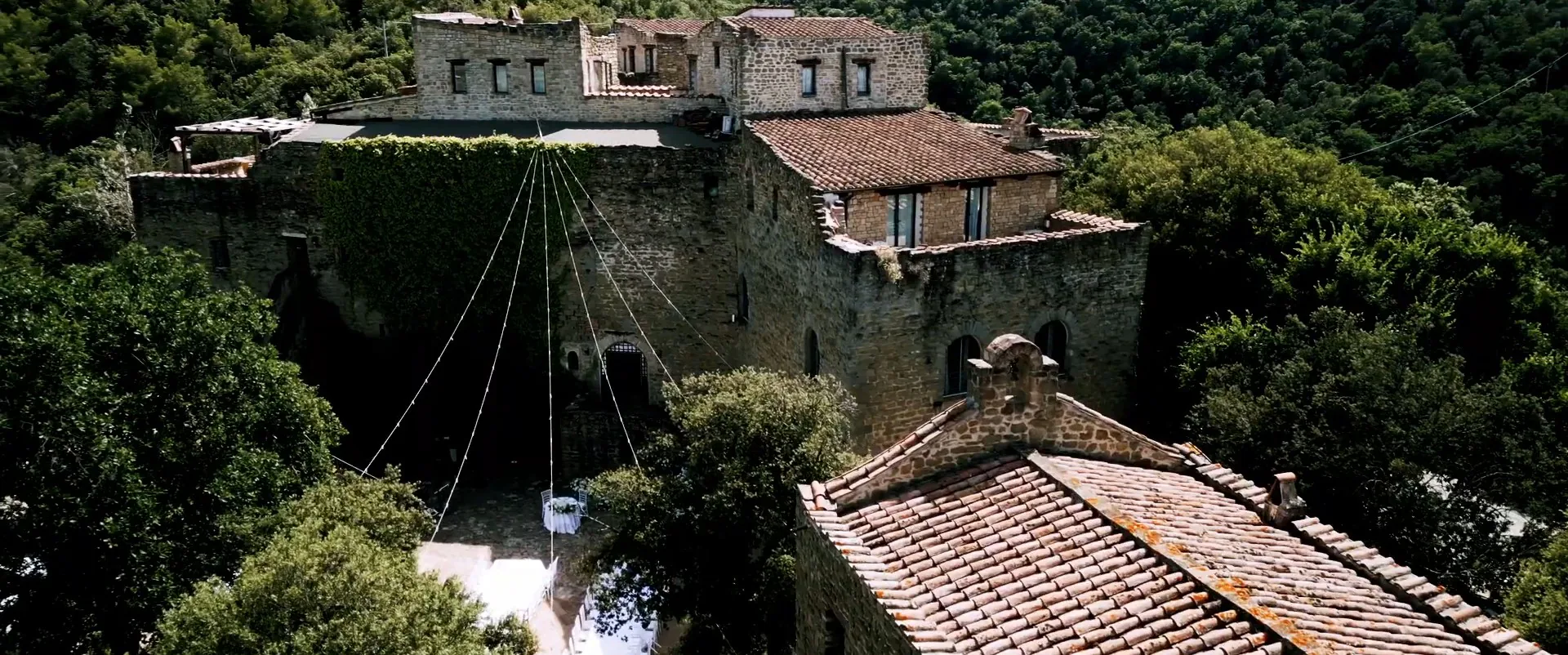 Le mura e i tetti del Castello di Rosciano dall’alto, con le luci appese sul cortile, fotogramma dal film di Gianni e Sophie