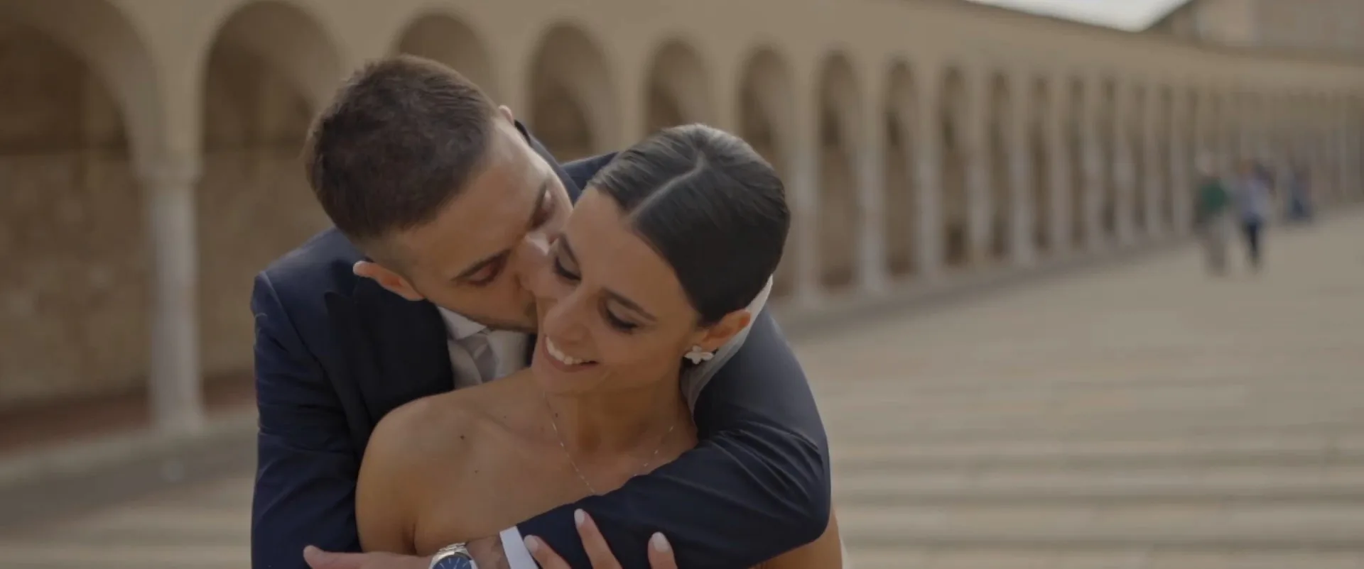 Giulia e Alessandro abbracciati sotto i portici della basilica di San Francesco
