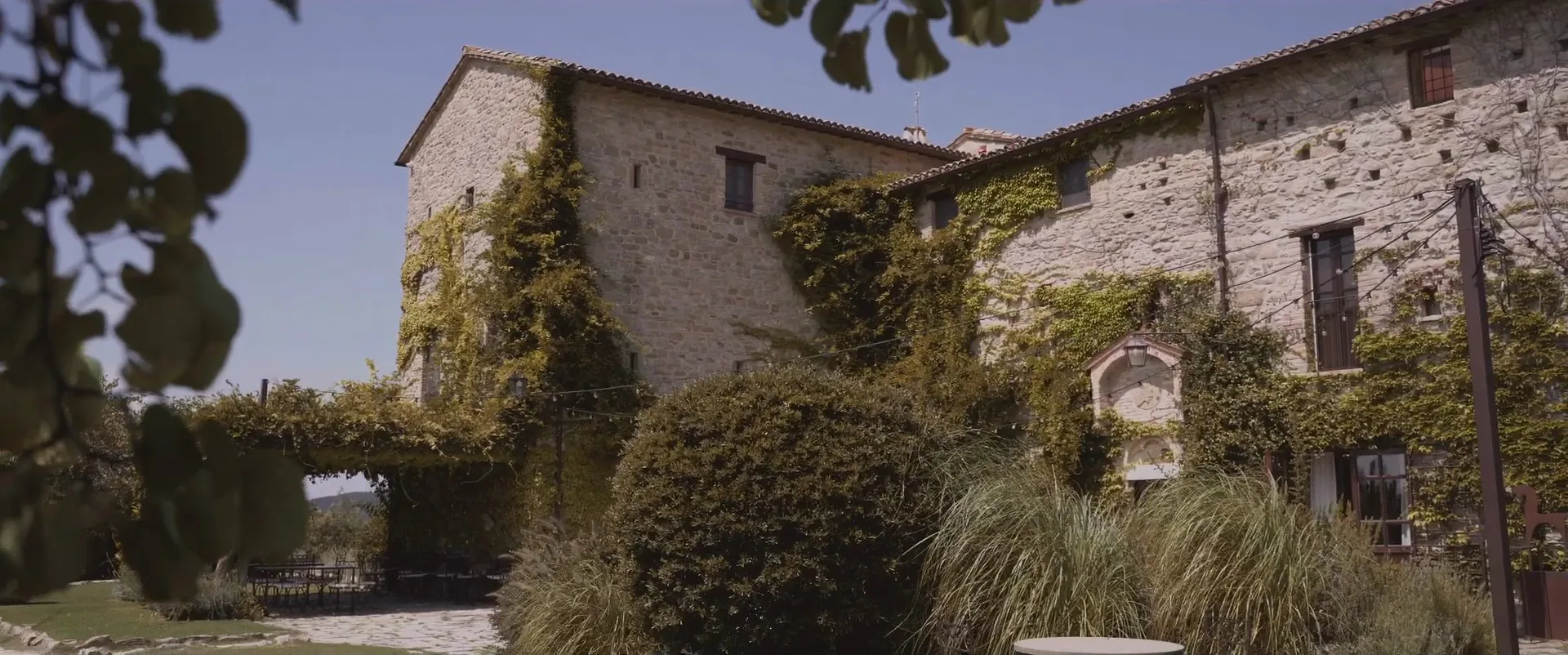 La facciata in pietra e edera del Castello di Petrata, ad Assisi, fotogramma dal film di Luigi e Christina
