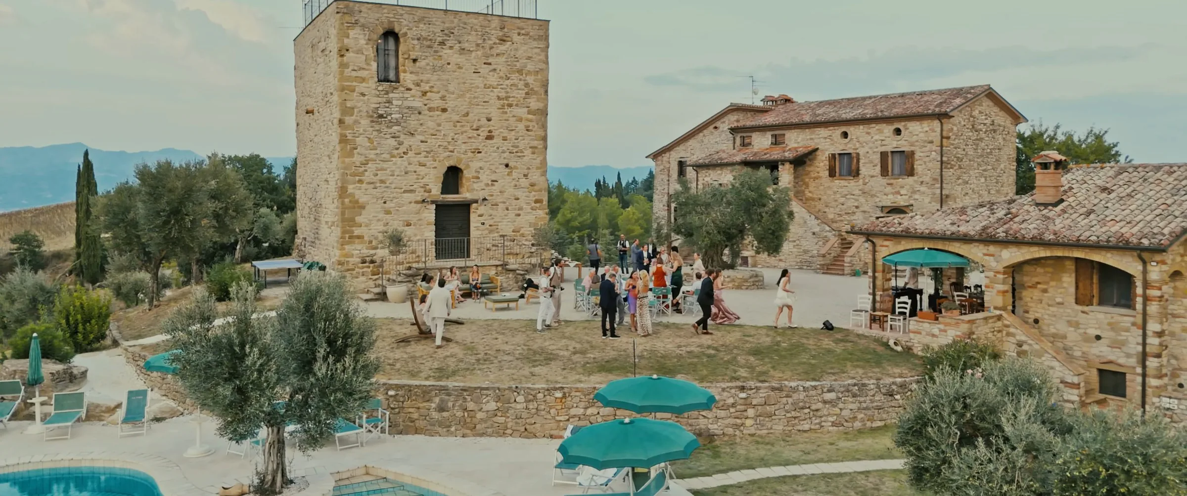 Gli ospiti davanti alla torre medievale e al casale della Torre di Celle, fotogramma dal film di Tyler e Jaime